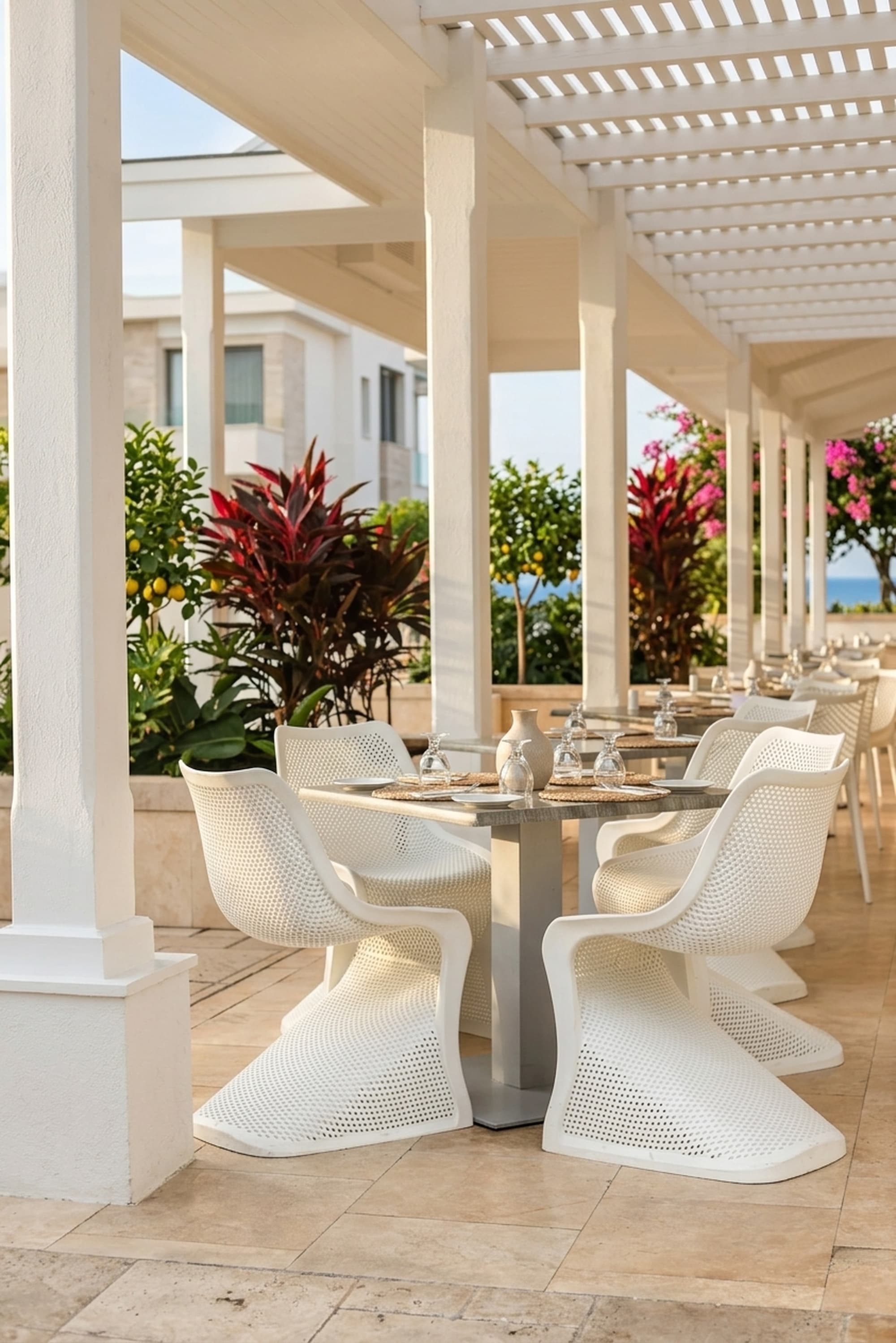 Outdoor patio table and chairs beside a pool with palm trees